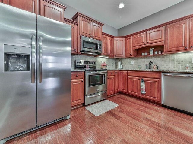 535 Crested Hawk Rdg, Canton, GA 30114 - kitchen with light stone counters, a sink, light wood-style flooring, backsplash, and appliances with stainless steel finishes