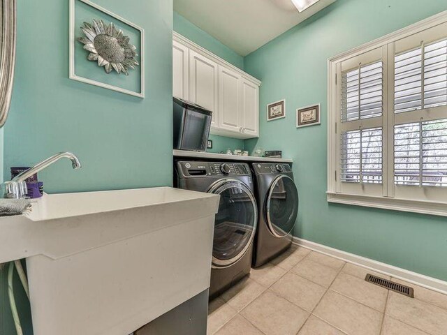 535 Crested Hawk Rdg, Canton, GA 30114 - laundry room with tile patterned floors, cabinet space, washing machine and dryer, baseboards, and visible vents