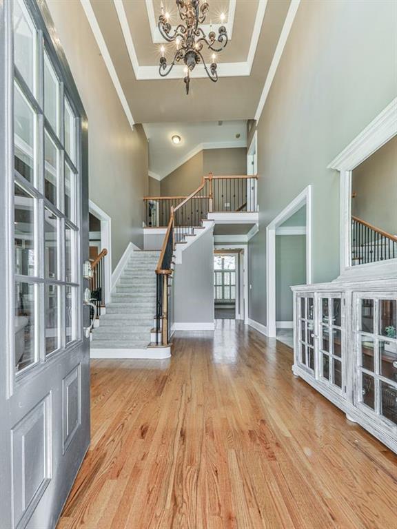 535 Crested Hawk Rdg, Canton, GA 30114 - foyer entrance with stairway, wood finished floors, an inviting chandelier, a high ceiling, and ornamental molding
