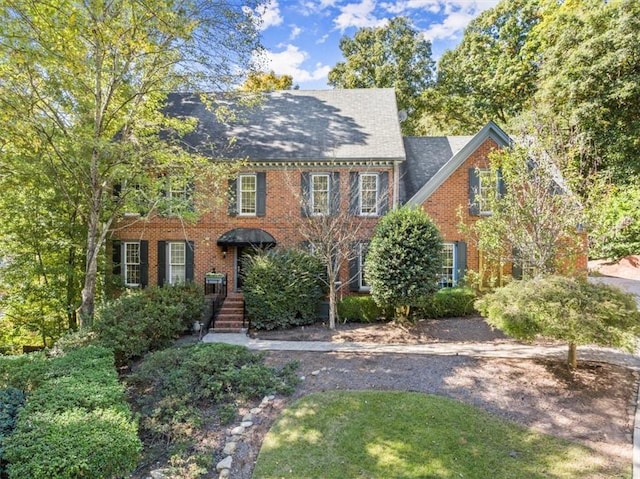 colonial inspired home featuring brick siding