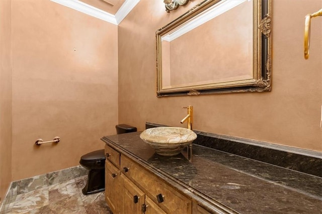 bathroom featuring toilet, ornamental molding, and vanity