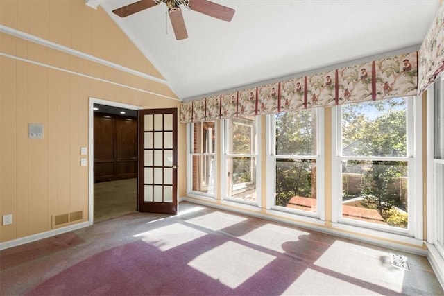 unfurnished room with carpet floors, visible vents, vaulted ceiling, and ceiling fan