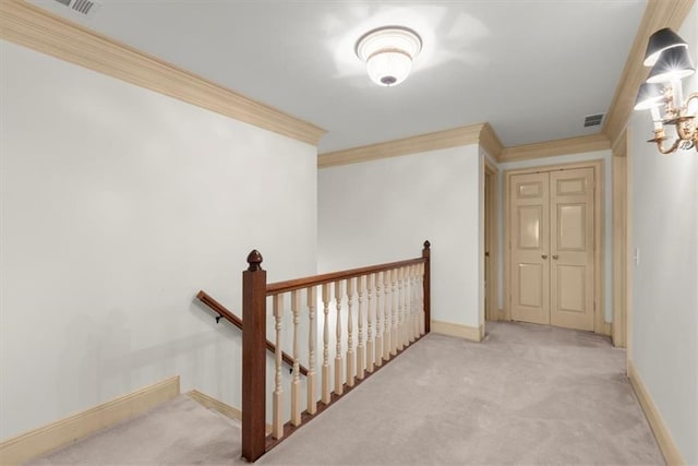 corridor featuring visible vents, carpet floors, an upstairs landing, and crown molding