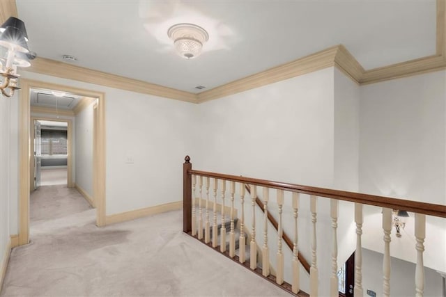 corridor featuring crown molding, light colored carpet, attic access, an upstairs landing, and baseboards