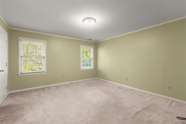 empty room featuring ornamental molding, carpet, and baseboards