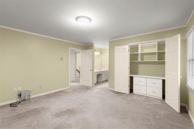 unfurnished bedroom with connected bathroom, baseboards, carpet flooring, and ornamental molding