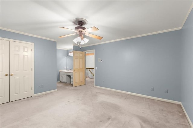 unfurnished bedroom featuring a closet, light colored carpet, ornamental molding, a ceiling fan, and baseboards