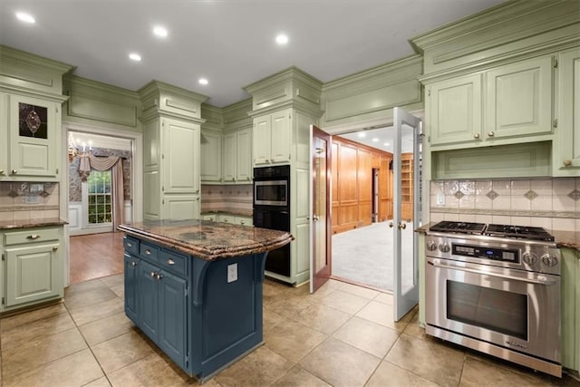 kitchen featuring light tile patterned floors, a kitchen island, appliances with stainless steel finishes, decorative backsplash, and dark stone countertops