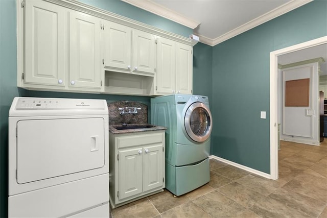 laundry area with cabinet space, baseboards, independent washer and dryer, crown molding, and a sink