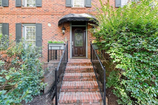 view of exterior entry featuring brick siding