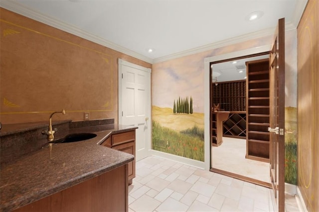 wine cellar with ornamental molding, a sink, and recessed lighting