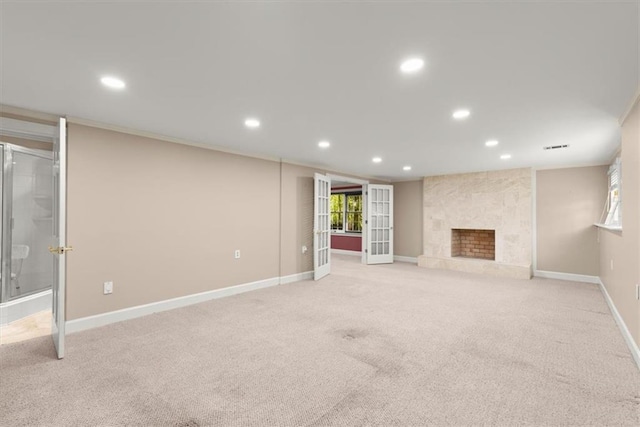 unfurnished living room with recessed lighting, a fireplace, baseboards, and french doors