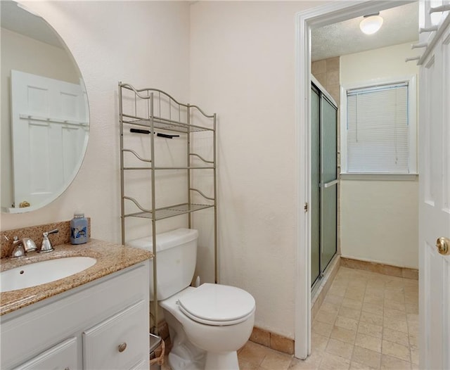 bathroom featuring vanity, a shower with door, toilet, and tile patterned flooring