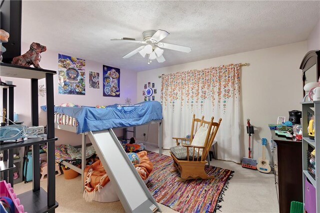 bedroom with ceiling fan, a textured ceiling, and light carpet