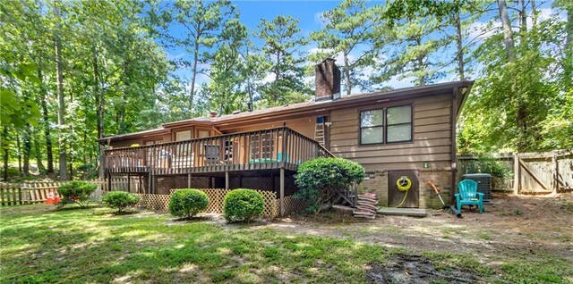 back of property featuring a wooden deck and a yard