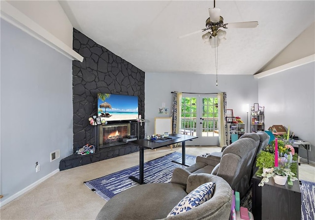 carpeted living room featuring ceiling fan, french doors, vaulted ceiling, and a large fireplace