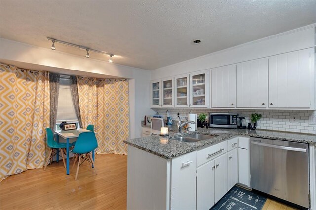 kitchen featuring light wood-type flooring, sink, stainless steel appliances, and white cabinetry