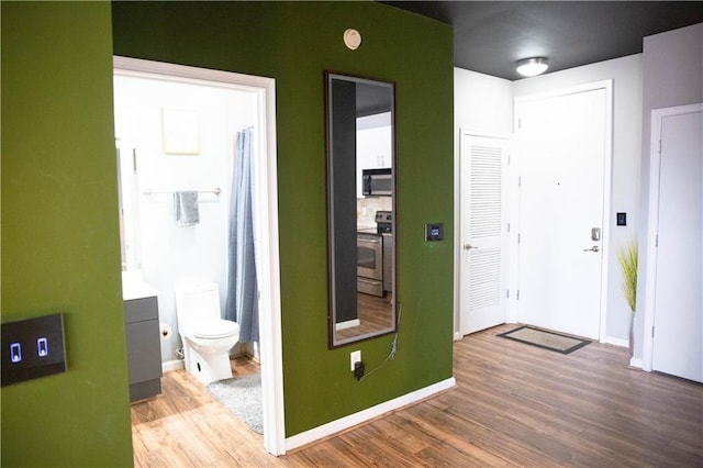 foyer entrance with baseboards and wood finished floors