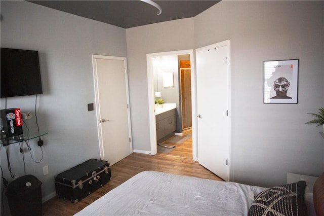 bedroom featuring ensuite bathroom and light wood-type flooring