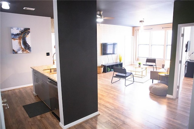 interior space with a ceiling fan, baseboards, visible vents, and wood finished floors