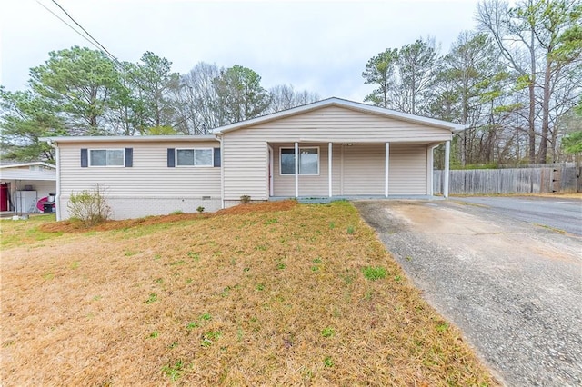 single story home featuring a front lawn, fence, and driveway