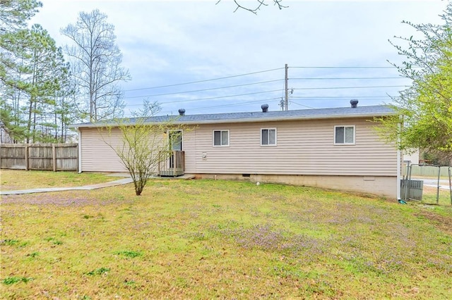 back of property featuring a lawn, cooling unit, and fence