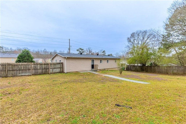 back of property with a yard and fence