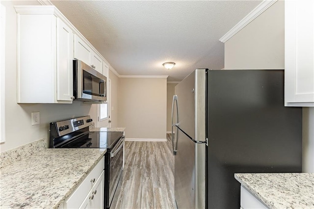 kitchen with light wood finished floors, white cabinets, appliances with stainless steel finishes, a textured ceiling, and crown molding