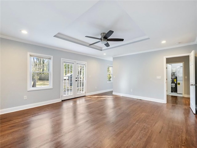 unfurnished room with a raised ceiling, a wealth of natural light, and french doors