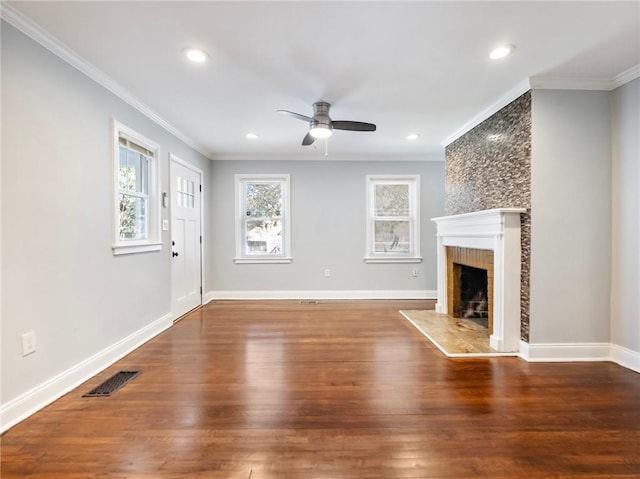 unfurnished living room featuring a fireplace, wood finished floors, a ceiling fan, visible vents, and crown molding