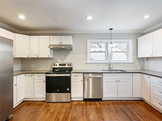 kitchen with appliances with stainless steel finishes, crown molding, under cabinet range hood, white cabinetry, and a sink