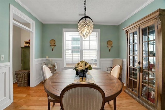 125 Rabbits Run, Fayetteville, GA 30215 - dining space with a chandelier, light wood-style flooring, a wainscoted wall, a decorative wall, and a textured ceiling