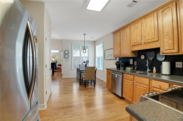 125 Rabbits Run, Fayetteville, GA 30215 - kitchen featuring appliances with stainless steel finishes, dark countertops, light wood-style floors, and a sink