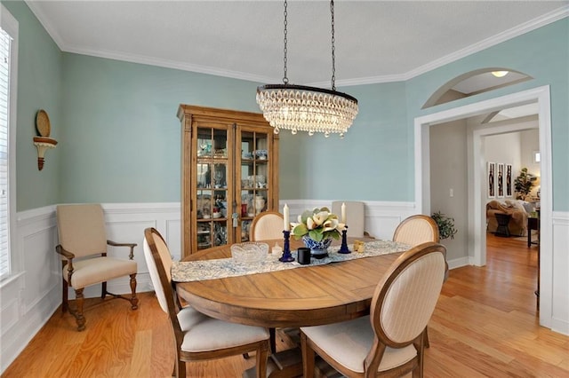 125 Rabbits Run, Fayetteville, GA 30215 - dining room with light wood-style floors, a chandelier, wainscoting, crown molding, and a decorative wall