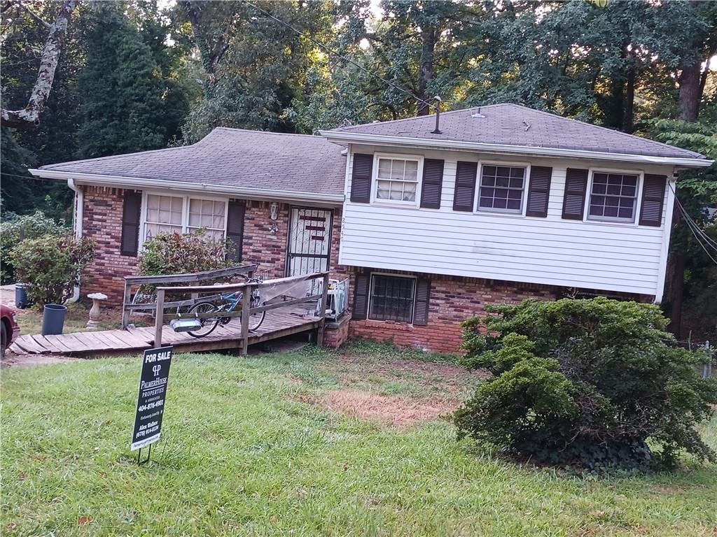 split level home featuring a deck and a front yard