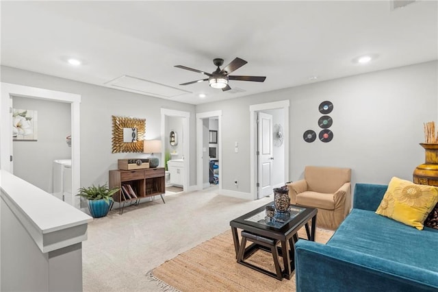 living area with a ceiling fan, washer and dryer, light colored carpet, recessed lighting, and baseboards