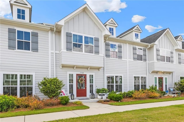 multi unit property featuring board and batten siding and a front lawn