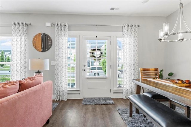 doorway featuring a chandelier and dark wood-style floors