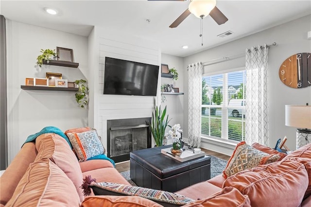 living room with ceiling fan, wood finished floors, a large fireplace, and recessed lighting