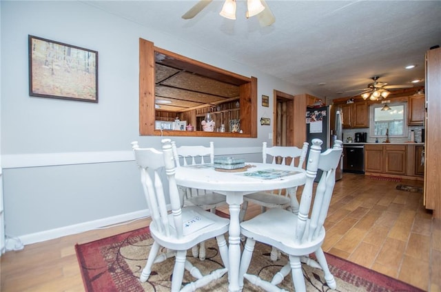 dining room with ceiling fan, light hardwood / wood-style flooring, and a textured ceiling