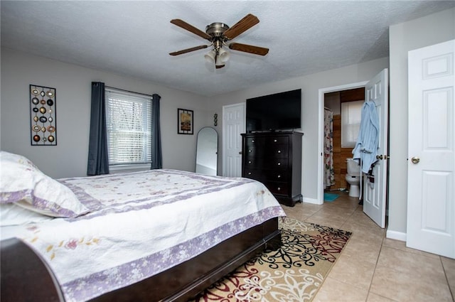 tiled bedroom featuring ceiling fan, a textured ceiling, and ensuite bath