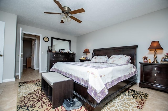 tiled bedroom with ceiling fan and a textured ceiling