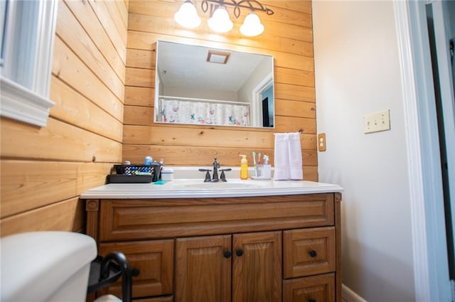 bathroom featuring vanity and wood walls