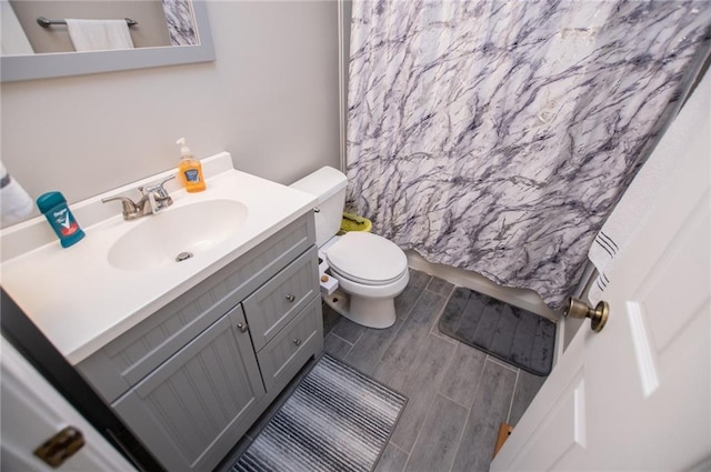 bathroom with vanity, a shower with shower curtain, and toilet