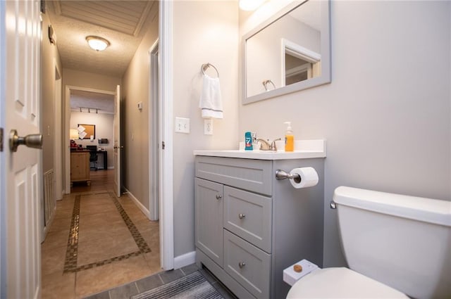 bathroom with vanity, tile patterned flooring, a textured ceiling, and toilet