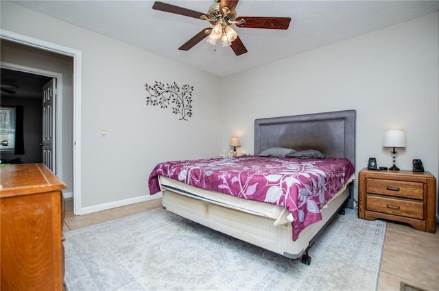 tiled bedroom featuring ceiling fan