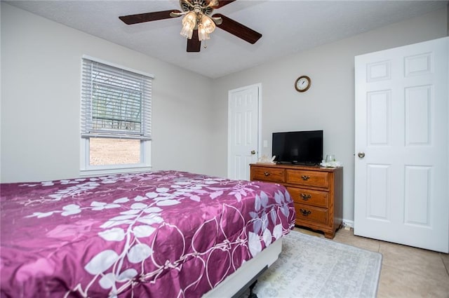 bedroom with ceiling fan and light tile patterned flooring