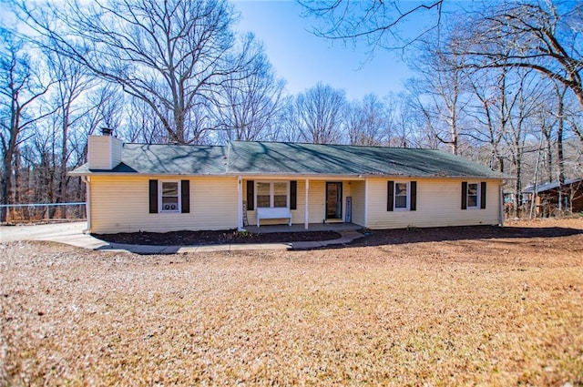 ranch-style house with a porch and a front lawn