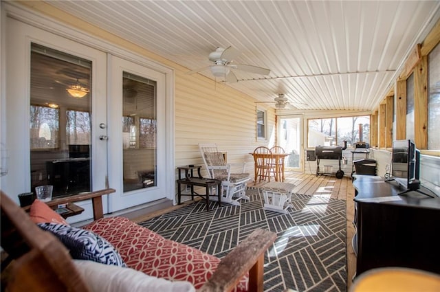 sunroom / solarium featuring ceiling fan and french doors