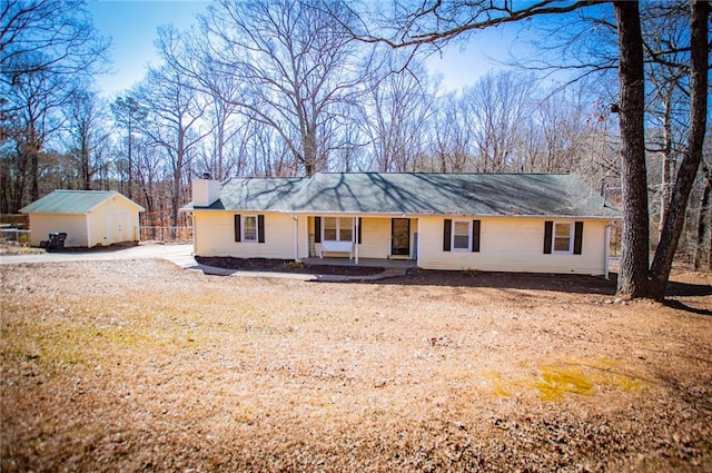 ranch-style house featuring an outbuilding and a porch